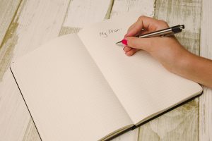 A female hand writing a plan in a notebook