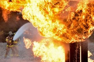 Fireman extinguishing a large fire - it can be caused by common packing mistakes