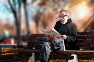 A gentleman in a park, reading newspaper 