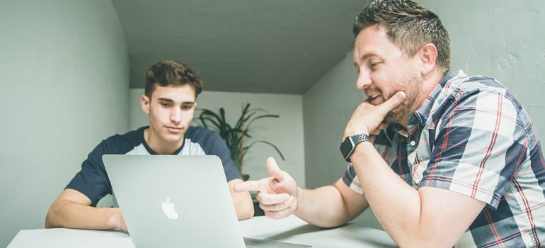One man showing another something on his computer