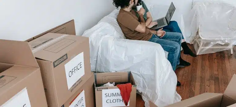 A couple sitting amid boxes explores things they shuld do right after you move