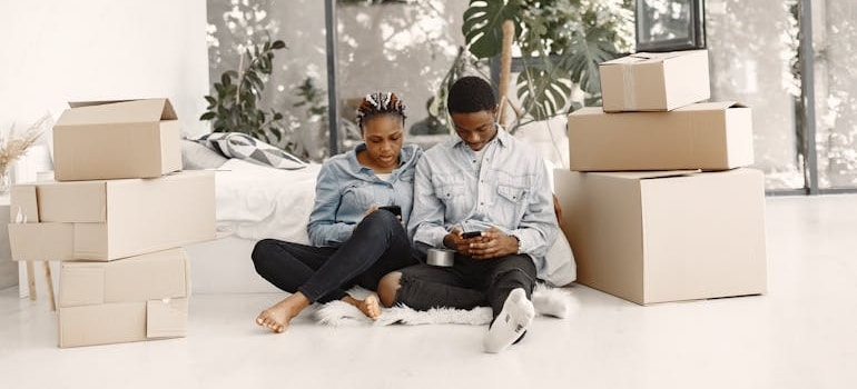 A couple sitting and trying to pick the right last minute movers