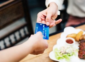 An individual paying for a nutritious meal via pay card