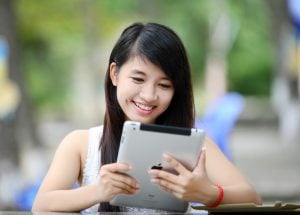 girl on tablet looking for the cheapest neighborhoods in Miami