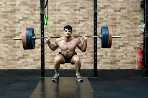 A man doing a squat with a heavy load.