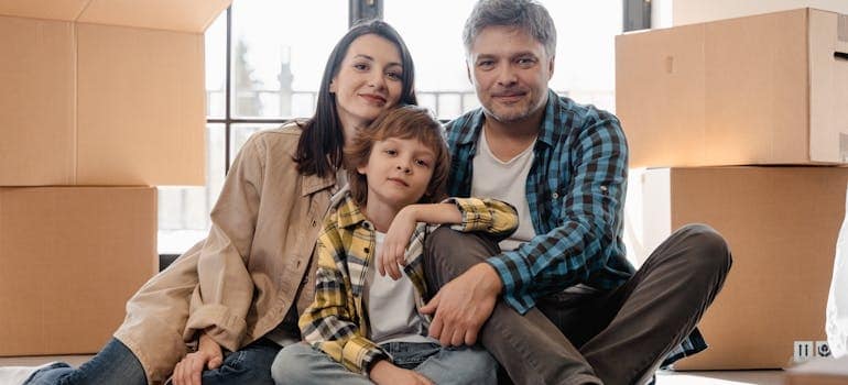Parents sitting with a boy next to moving boxes