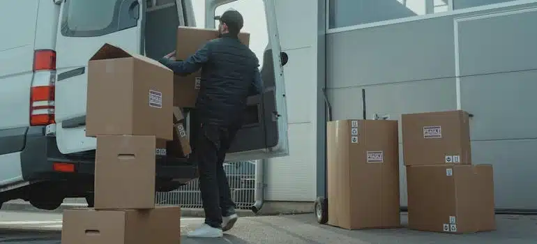 A man emptying storage and loading boxes in a van