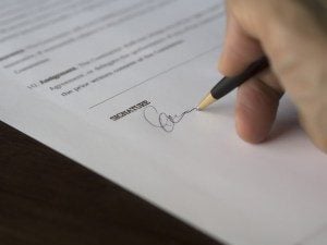 Person signing a contract.