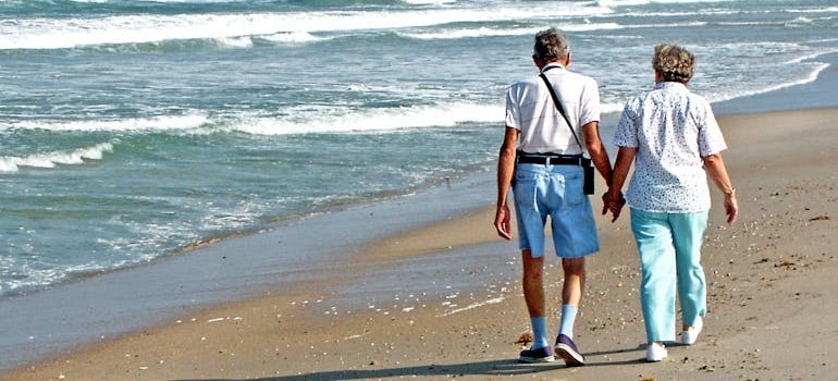 An elderly couple walking by the sea