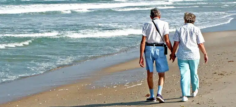An elderly couple walking by the sea