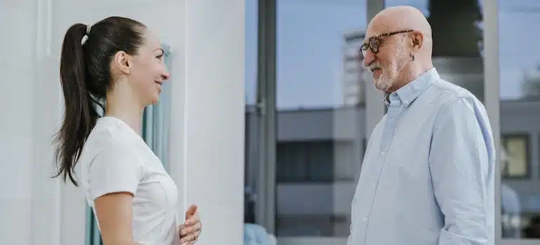 A young female nurse and an elderly man talking