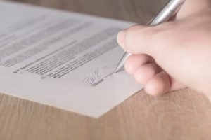 Person signing a contract.