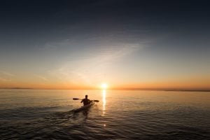 Picture of man kayaking into the sunset