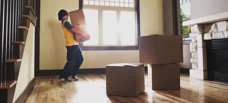 Boy carrying boxes in house