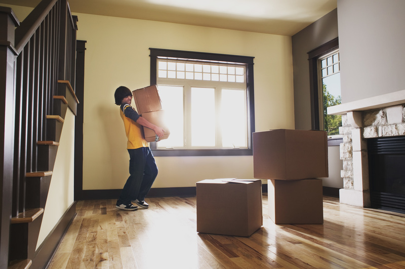 Boy carrying boxes in house