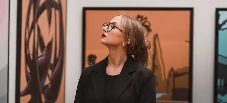 A woman observing a painting in one of the best art galleries in Miami