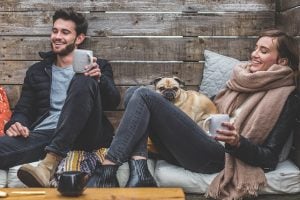 Man and woman with a pug drinking coffee