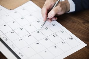 A man pointing at a calendar.