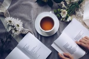 A view of a cup of coffee and two books on a table.