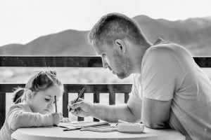 A man and a girl sitting at a table.