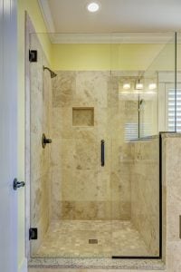 A shower with beige tiles.