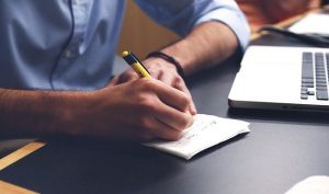 Man writing a moving checklist