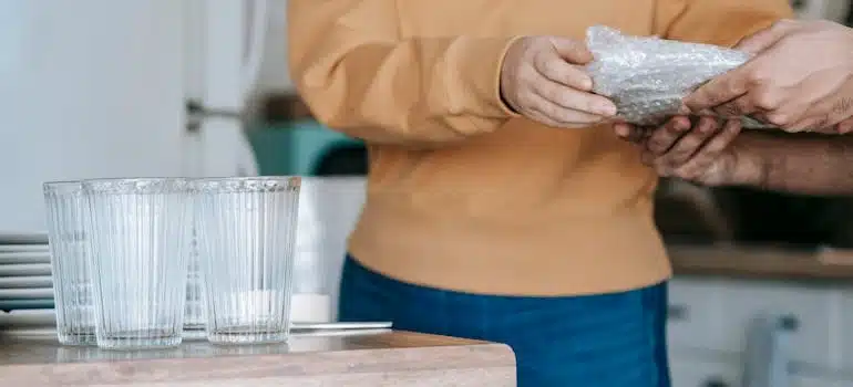 A woman showing how to pack your glassware and fine china for storage