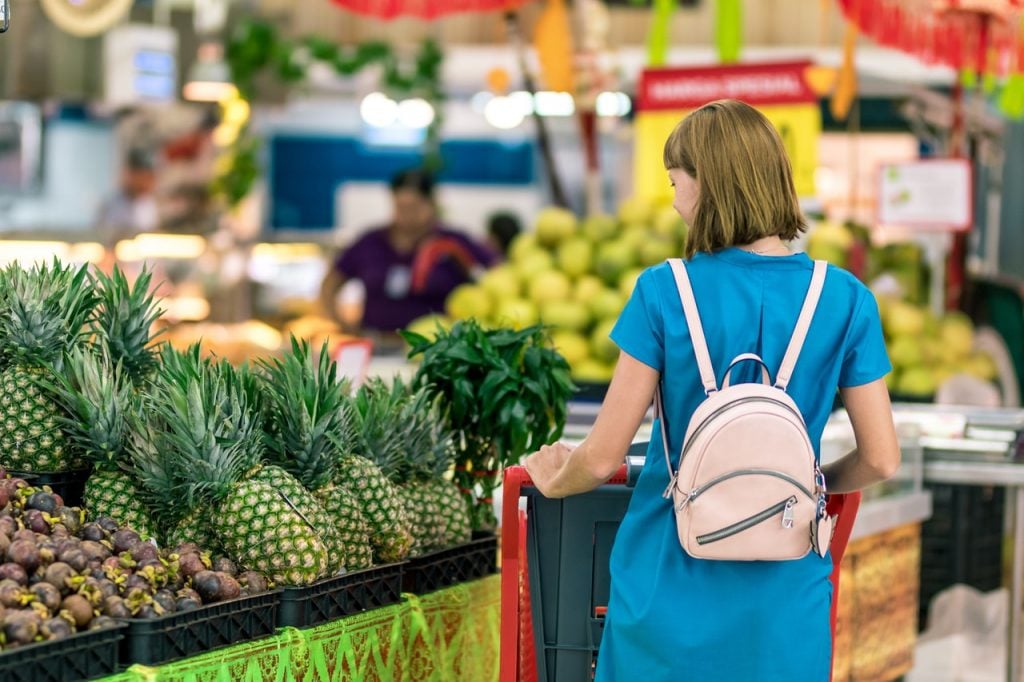 Woman standing in a retail store next to pineapples