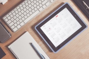 Tablet and a notebook on a wooden desk