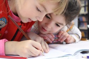 two girls looking at a notebook