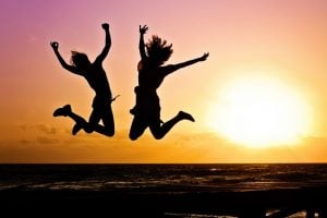 Two girls jumping on the beach