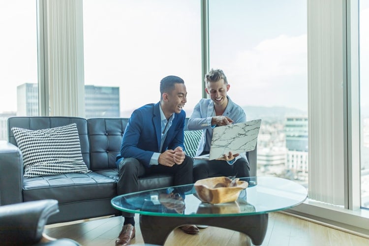 two men with a laptop working