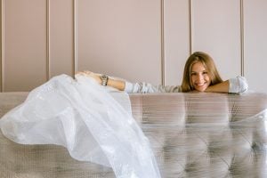 woman smiling behind a wrapped-up headboard