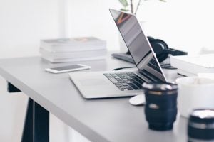 a laptop and a cup on a working desk