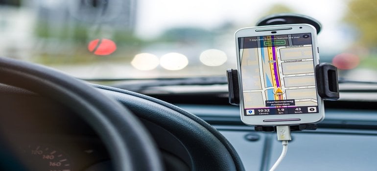 must-have apps when moving to a new town -a phone showing a map in a car
