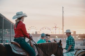 woman with a cowboy hat riding a horse