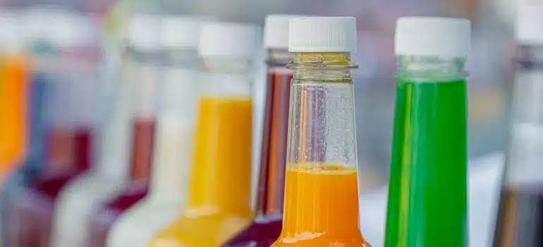 A row of bottles with liquids in a fridge