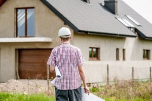 Picture of a contractor in front of the house. Make repairs before selling your luxury home.