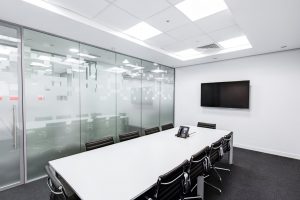 a photo of an office after moving offices in the Miami Dade area, a long desk with chairs, and a TV on the wall