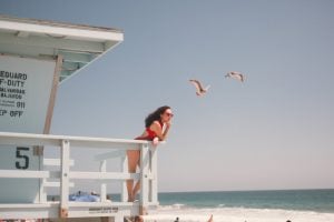 woman standing on a lifeguard post