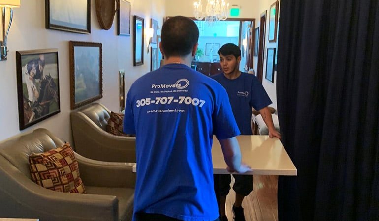 Two of our movers handling a table.