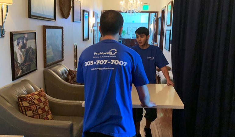 Two of our movers handling a table. 