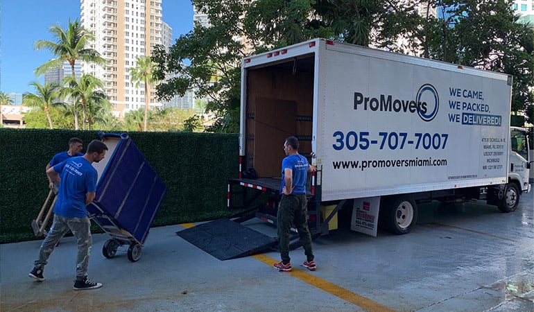 Movers ready to load, unload, and drive a truck. 