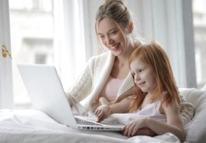Picture of a woman and kid looking something on a laptop