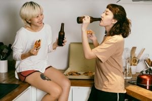 Picture of two girls eating pizza and drinking beer