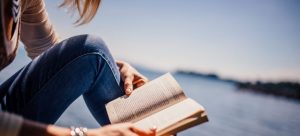 Woman reading near water