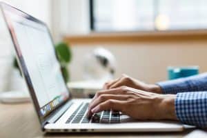 a person writing on a laptop