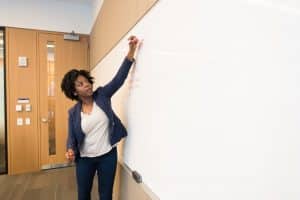 Woman writing on blackboard.