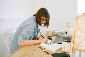 A woman writing in her home office.