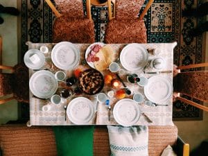 Dinner set on table surrounded with padded chairs